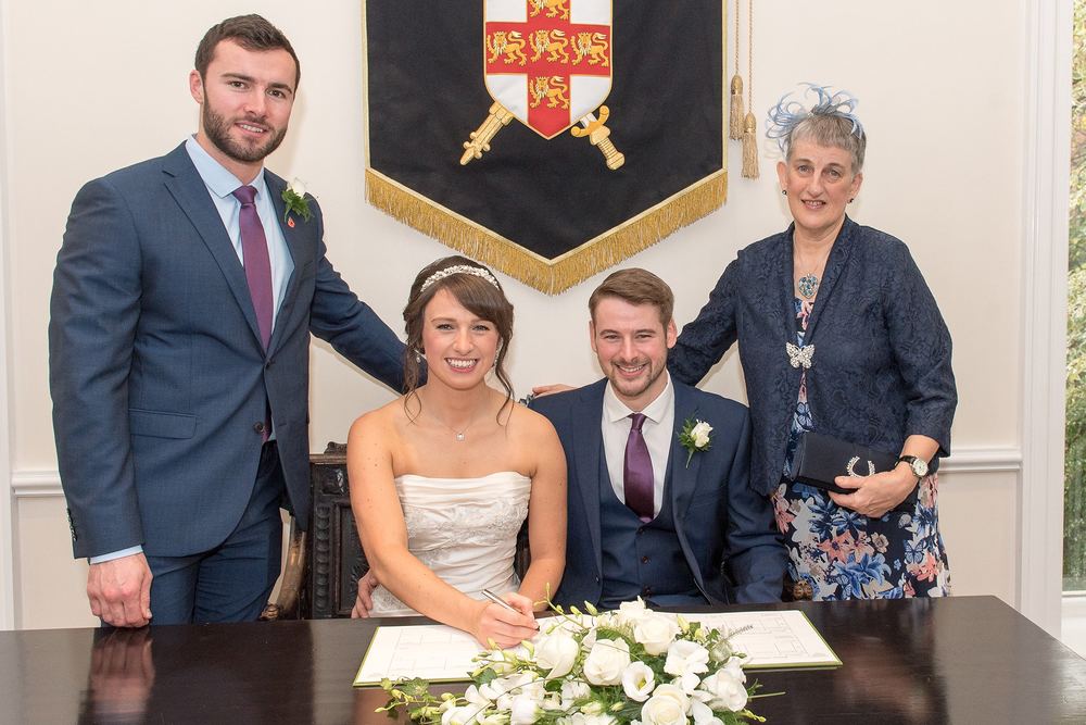 The bride and groom sign the register with their witnesses at York Register Office.