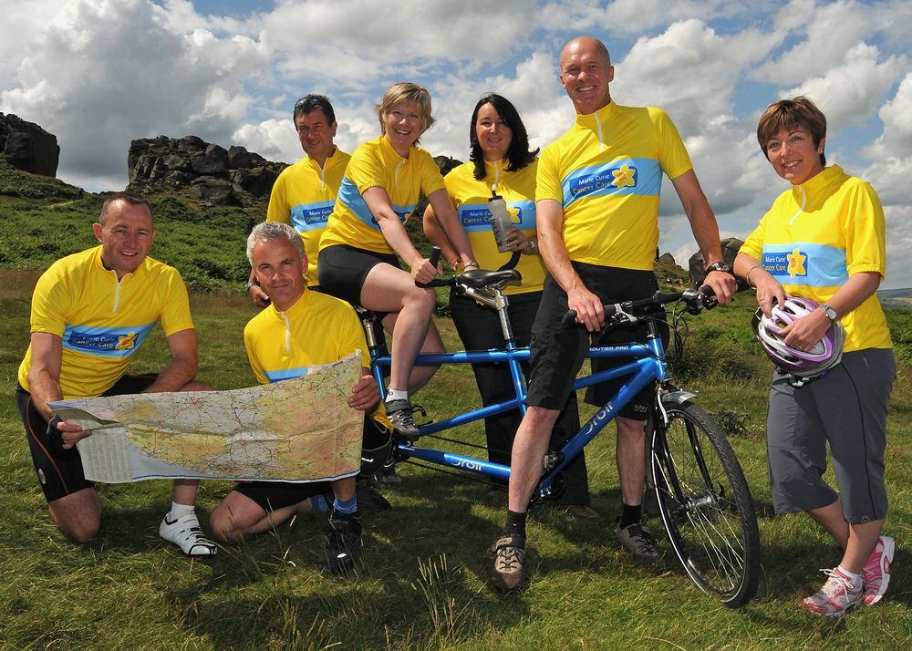 A team of tandem cyclists in Marie Curie charity T-shirts at the Cow and Calf.