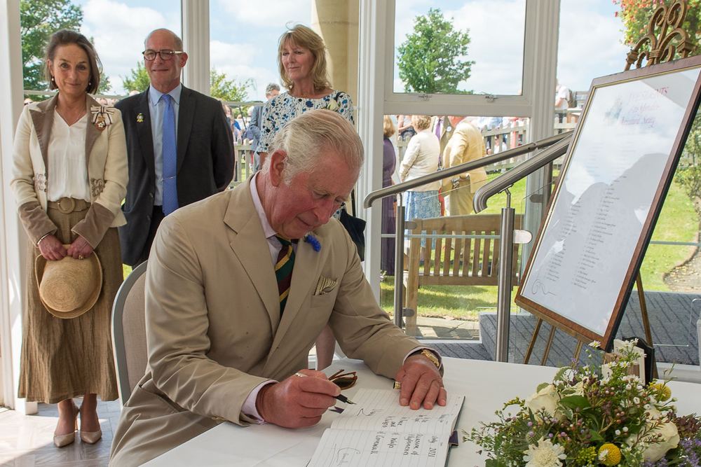 King Charles signing the visitors' book at the Great Yorkshire Show.