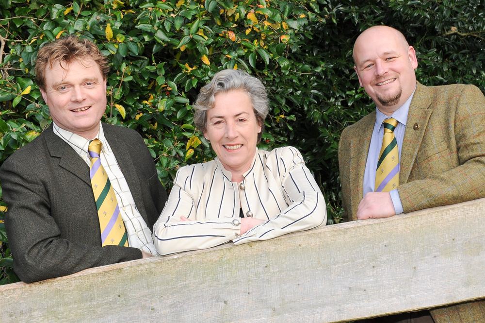 Three staff members photographed for a college announcement.