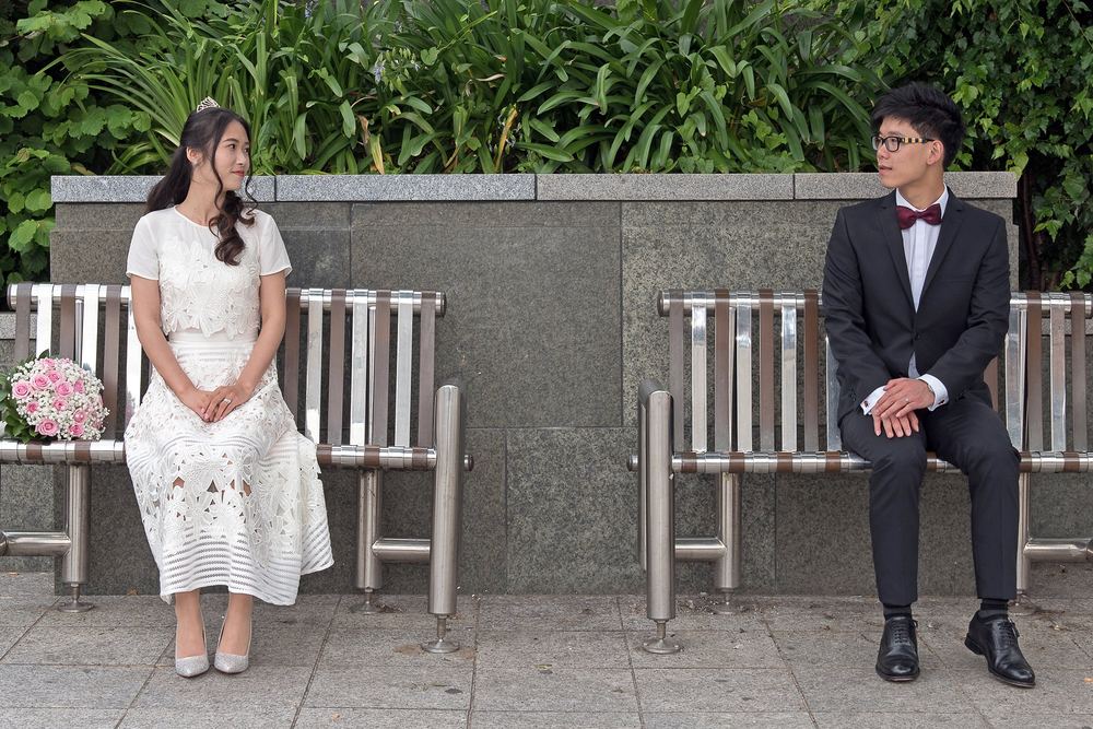Xuanhui & Chaojie on separate benches in Leeds city centre after their wedding at Leeds Town Hall.