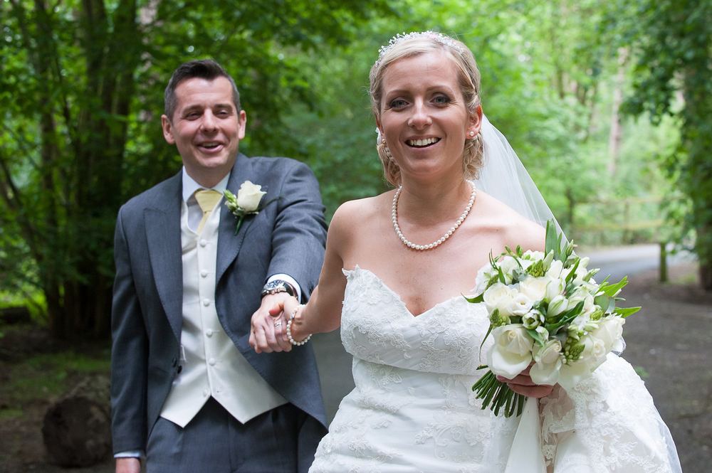 Laura-Jane and Tim run through the woods after their wedding.