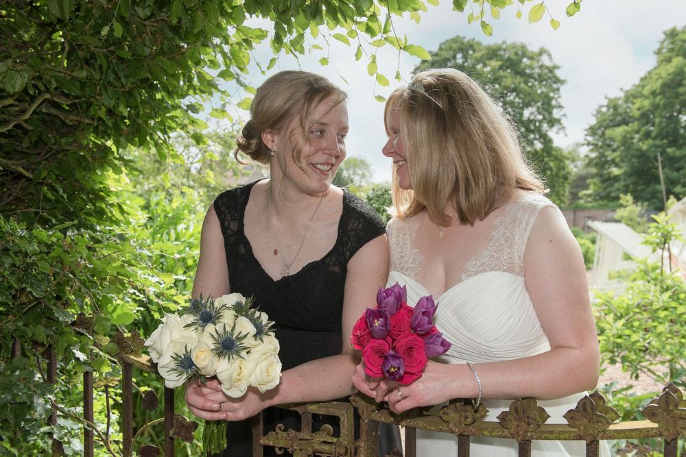 Two brides chat and smile after their wedding at The Little Theatre, Skipwith Hall.