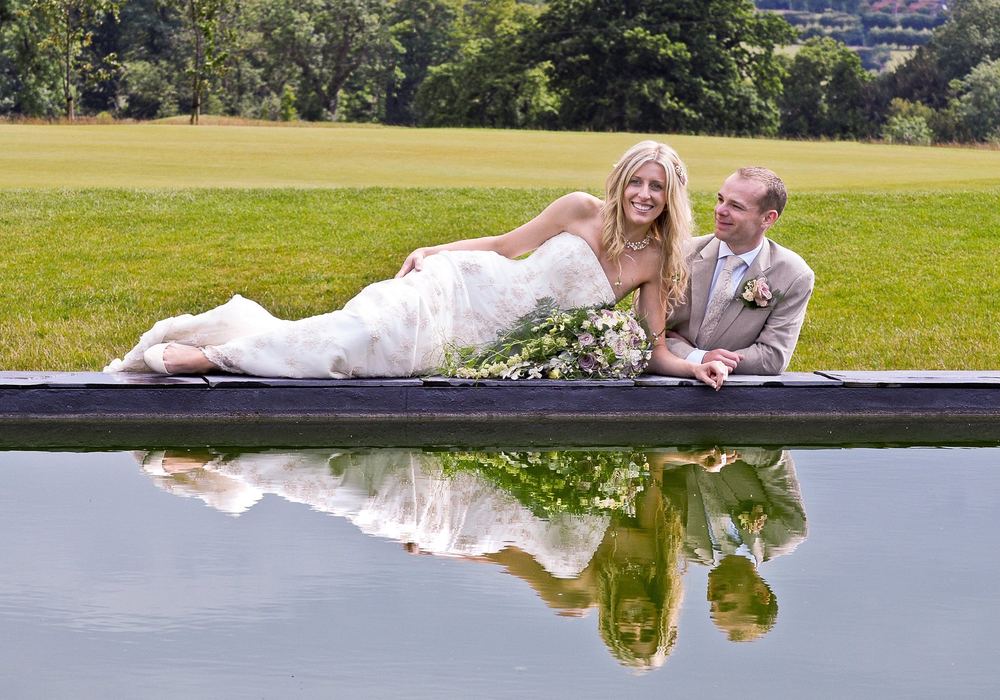 A pond-reflection shot of Danielle and Dan after their wedding at The KP Club, Pocklington.