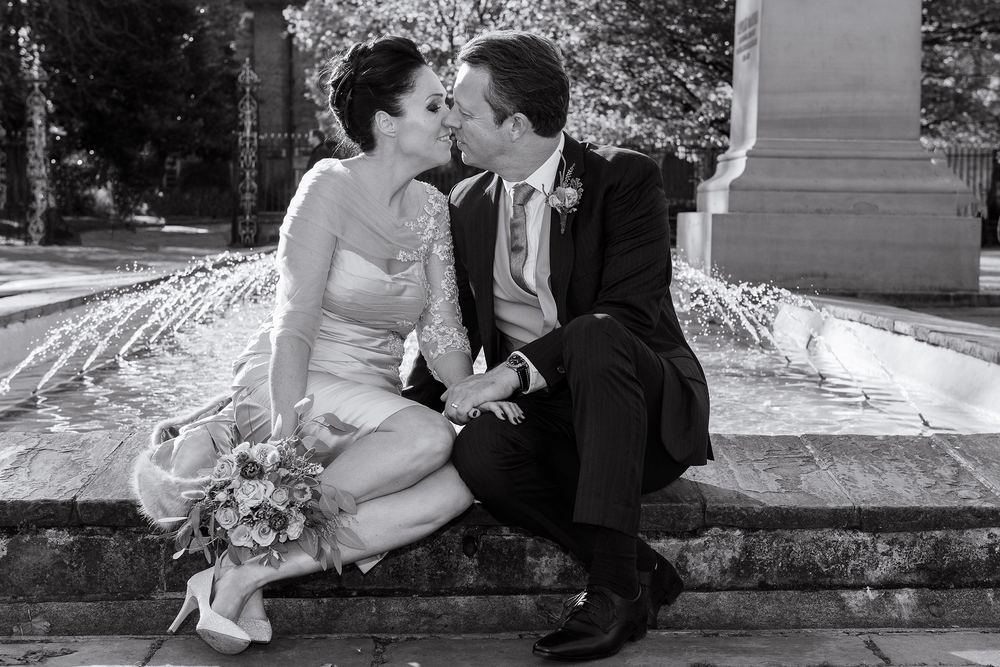 Zoe & Andrew beside a fountain after their wedding at York Register Office.