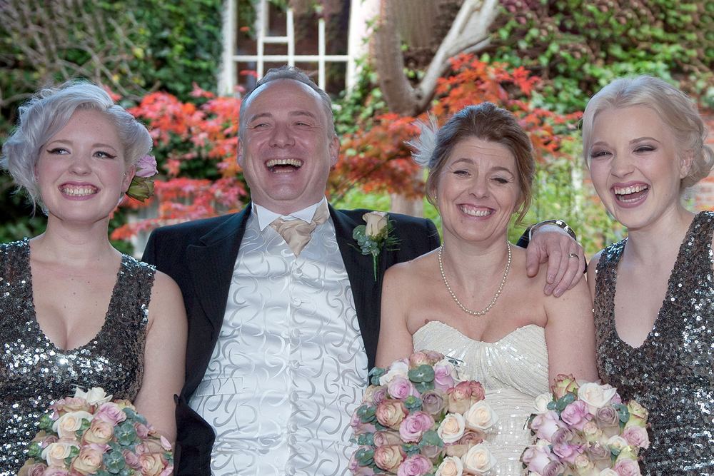 The bride, groom and bridesmaids laugh together at York Pavilion Hotel, Fulford.