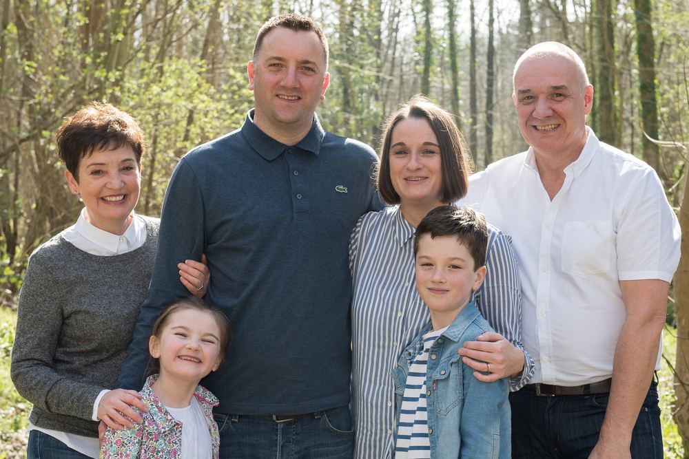 A multi-generational family portrait — grandparents, parents and children — in a Yorkshire forest setting.