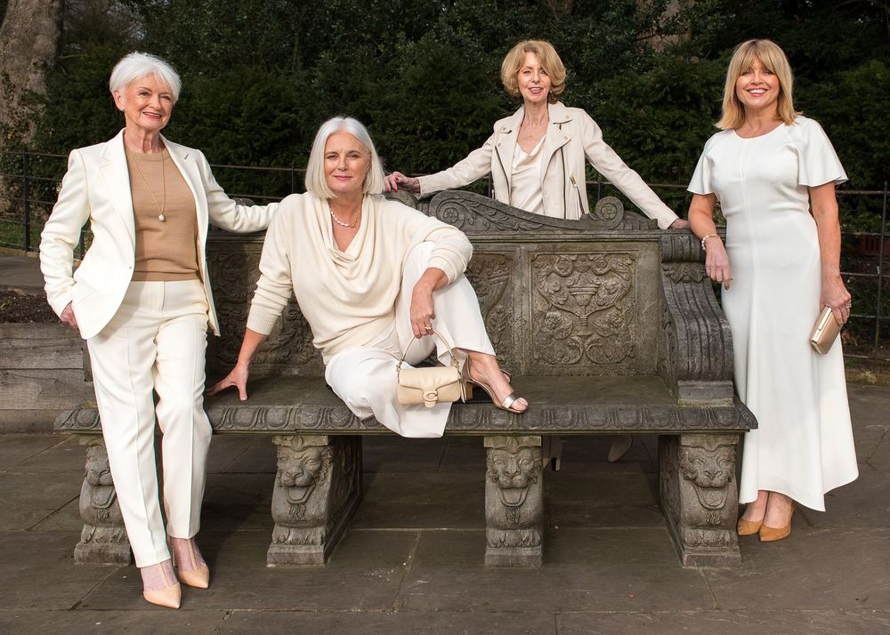 Three friends in coordinated neutral outfits, photographed outdoors.