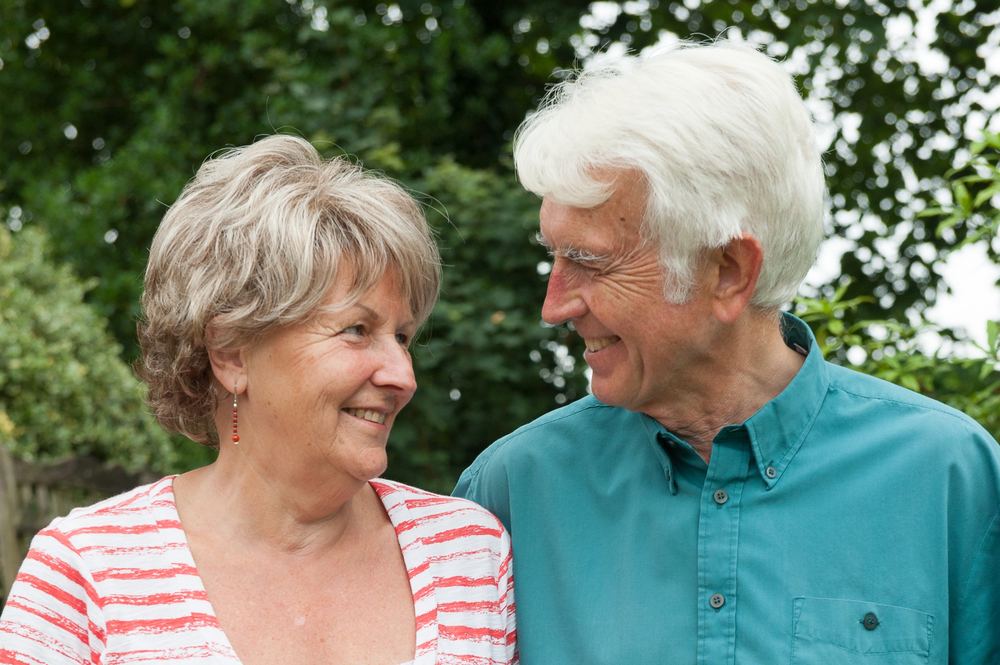 An elderly couple look adoringly at each other.