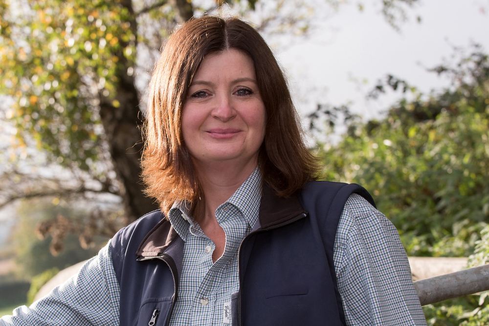 A strong, confident portrait of a woman in the countryside.